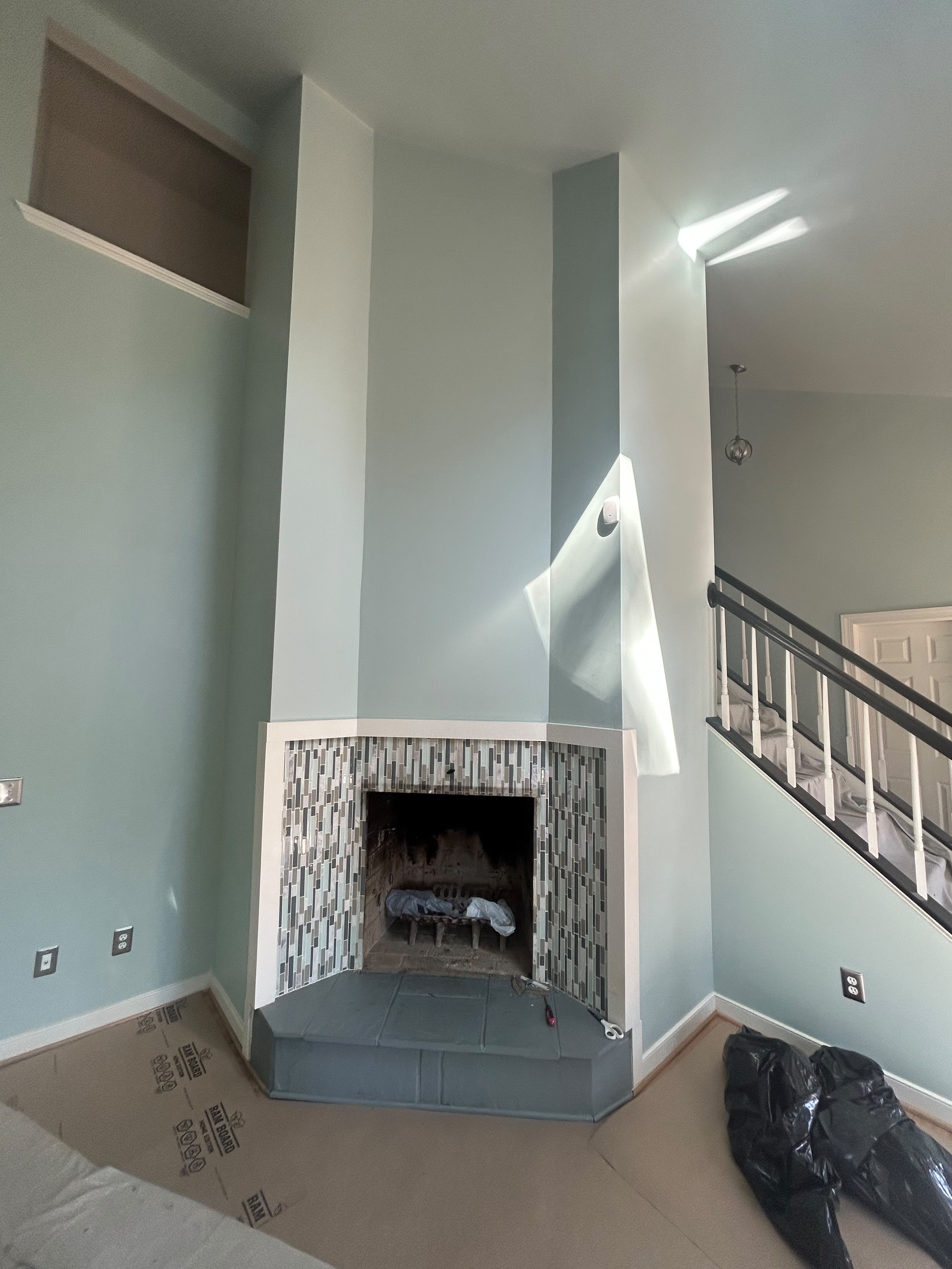 Corner fireplace surround before renovation — bare concrete block and fresh drywall